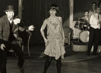 Movie still from “Daisies” (1966), directed by Vera Chytilová – A woman in an old fashioned dress is posing for a picture; Medium shot, High angle