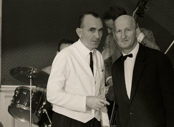 Movie still from “Daisies” (1966), directed by Vera Chytilová – Two men in suits standing next to each other; Medium shot, Low angle