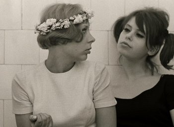 Movie still from “Daisies” (1966), directed by Vera Chytilová – Two young women sitting next to each other; Close Up shot, Low angle