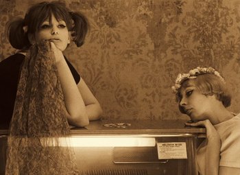 Movie still from “Daisies” (1966), directed by Vera Chytilová – Two young women sitting on a counter in front of an old fashioned radio; Close Up shot, Low angle