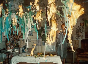 Movie still from “Daisies” (1966), directed by Vera Chytilová – A table with a bunch of papers hanging from the ceiling; Wide shot, Overhead angle