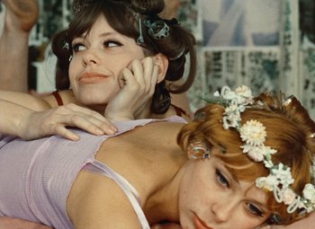 Movie still from “Daisies” (1966), directed by Vera Chytilová – Two women with their hair in a bun and one is on the phone; Close Up shot, High angle