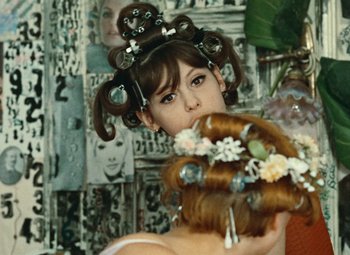 Movie still from “Daisies” (1966), directed by Vera Chytilová – A woman with a bunch of hair on her head; Close Up shot, Over the shoulder angle