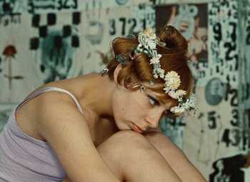 Movie still from “Daisies” (1966), directed by Vera Chytilová – A woman sitting on the ground with her head resting on her knees; Close Up shot, High angle