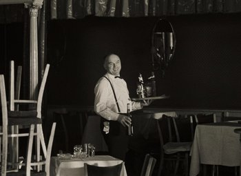 Movie still from “Daisies” (1966), directed by Vera Chytilová – A man holding a tray in a restaurant; Medium shot, Low angle