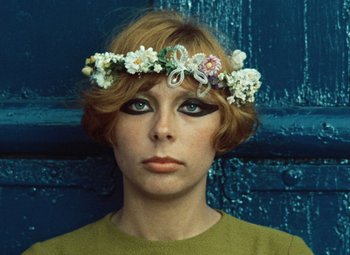 Movie still from “Daisies” (1966), directed by Vera Chytilová – A person wearing a wreath of flowers; Close Up shot, Overhead angle