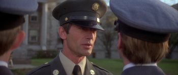 Movie still from “Damien: Omen II” (1978), directed by Mike Hodges – A man in a uniform talking to another man; Close Up shot, Over the shoulder angle