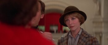 Movie still from “Damien: Omen II” (1978), directed by Mike Hodges – A woman wearing a brown hat talking to a man in a red shirt; Close Up shot, Over the shoulder angle