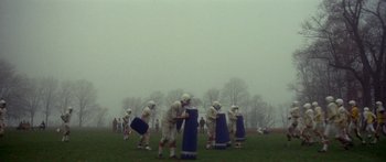 Movie still from “Damien: Omen II” (1978), directed by Mike Hodges – A group of men playing football on a field; Extreme Wide shot, High angle