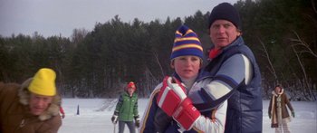 Movie still from “Damien: Omen II” (1978), directed by Mike Hodges – A man and a boy are standing in the snow; Medium shot, Over the shoulder angle
