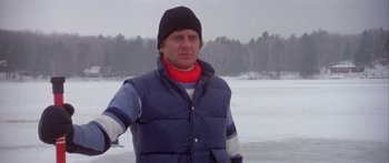 Movie still from “Damien: Omen II” (1978), directed by Mike Hodges – A man wearing a blue vest and a red scarf; Medium shot, Low angle