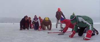 Movie still from “Damien: Omen II” (1978), directed by Mike Hodges – A group of young people playing a game of hockey on a frozen lake; Wide shot, High angle
