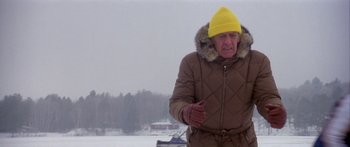 Movie still from “Damien: Omen II” (1978), directed by Mike Hodges – An older man wearing a yellow hat and a brown coat; Medium shot, Low angle