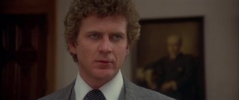 Movie still from “Damien: Omen II” (1978), directed by Mike Hodges – A person wearing a suit and tie; Close Up shot, Over the shoulder angle