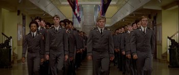 Movie still from “Damien: Omen II” (1978), directed by Mike Hodges – A group of young men in uniform walking down a hall way; Wide shot, Low angle