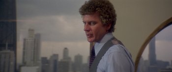 Movie still from “Damien: Omen II” (1978), directed by Mike Hodges – A person with curly hair wearing a tie; Close Up shot, Over the shoulder angle