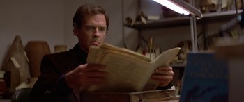 Movie still from “Damien: Omen II” (1978), directed by Mike Hodges – A man is reading a newspaper in a room; Close Up shot, Low angle