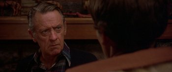 Movie still from “Damien: Omen II” (1978), directed by Mike Hodges – An older man looking at a younger man in the mirror; Close Up shot, Over the shoulder angle