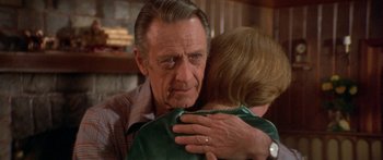 Movie still from “Damien: Omen II” (1978), directed by Mike Hodges – An older man is hugging a younger woman; Close Up shot, Over the shoulder angle