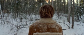Movie still from “Damien: Omen II” (1978), directed by Mike Hodges – A person wearing a brown jacket in the snow; Close Up shot, Over the shoulder angle