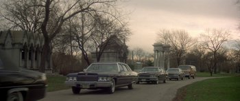 Movie still from “Damien: Omen II” (1978), directed by Mike Hodges – A group of cars driving down a street; Extreme Wide shot, High angle