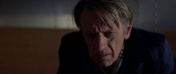 Movie still from “Damien: Omen II” (1978), directed by Mike Hodges – An older man is looking at the camera; Close Up shot, Low angle