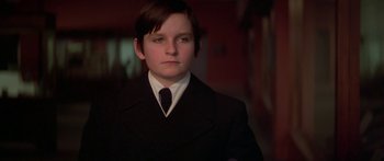 Movie still from “Damien: Omen II” (1978), directed by Mike Hodges – A young man in a suit and a tie; Close Up shot, Low angle