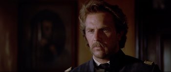 Movie still from “Dances with Wolves” (1990), directed by Kevin Costner – A person wearing a suit and tie; Close Up shot, Low angle