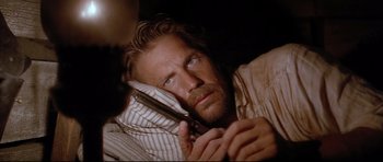 Movie still from “Dances with Wolves” (1990), directed by Kevin Costner – A person holding a cell phone; Close Up shot, High angle