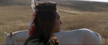 Movie still from “Dances with Wolves” (1990), directed by Kevin Costner – A man with long brown hair wearing a feather headdress; Close Up shot, Over the shoulder angle