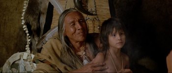 Movie still from “Dances with Wolves” (1990), directed by Kevin Costner – An older man and a young boy are sitting together; Close Up shot, Low angle