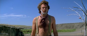 Movie still from “Dances with Wolves” (1990), directed by Kevin Costner – A man with long hair and a beard is wearing suspenders and a tie; Close Up shot, Low angle