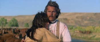 Movie still from “Dances with Wolves” (1990), directed by Kevin Costner – A man and a woman embracing each other in a field; Close Up shot, Low angle