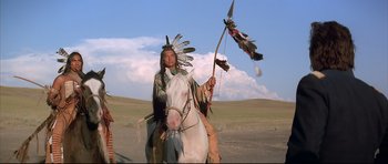 Movie still from “Dances with Wolves” (1990), directed by Kevin Costner – A man in native american garb riding a horse; Wide shot, Low angle
