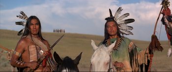 Movie still from “Dances with Wolves” (1990), directed by Kevin Costner – A man in a native american outfit on a horse; Medium shot, Over the shoulder angle