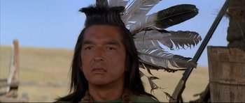 Movie still from “Dances with Wolves” (1990), directed by Kevin Costner – A person wearing a feather headdress; Close Up shot, Over the shoulder angle