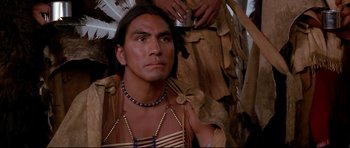 Movie still from “Dances with Wolves” (1990), directed by Kevin Costner – A man in a native american outfit looking at the camera; Close Up shot, Over the shoulder angle