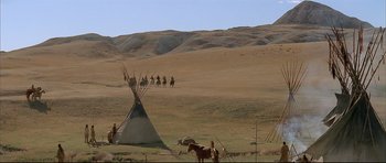 Movie still from “Dances with Wolves” (1990), directed by Kevin Costner – A group of people on horseback riding past a teepee; Extreme Wide shot, High angle
