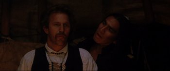 Movie still from “Dances with Wolves” (1990), directed by Kevin Costner – A man and a woman in a dark room; Close Up shot, Over the shoulder angle