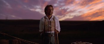 Movie still from “Dances with Wolves” (1990), directed by Kevin Costner – A man standing in front of a sunset; Medium shot, Low angle