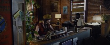 Movie still from “Danny Collins” (2015), directed by Dan Fogelman – A woman sitting at a desk in front of a typewriter; Medium shot, High angle
