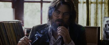 Movie still from “Danny Collins” (2015), directed by Dan Fogelman – A man smoking a pipe while wearing glasses and a jacket; Close Up shot, Low angle