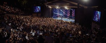 Movie still from “Danny Collins” (2015), directed by Dan Fogelman – A large crowd of people in a large auditorium; Extreme Wide shot, High angle