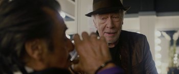 Movie still from “Danny Collins” (2015), directed by Dan Fogelman – An older man wearing a hat is drinking water; Close Up shot, Over the shoulder angle