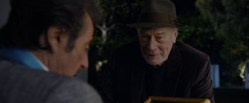 Movie still from “Danny Collins” (2015), directed by Dan Fogelman – An older man wearing a hat is looking at another man; Close Up shot, Over the shoulder angle