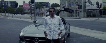Movie still from “Danny Collins” (2015), directed by Dan Fogelman – A man standing in front of a car on a street; Medium shot, Low angle