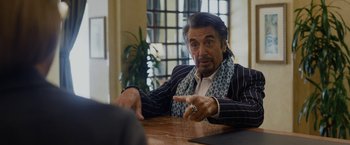 Movie still from “Danny Collins” (2015), directed by Dan Fogelman – A man sitting at a wooden table in front of a window; Medium shot, Over the shoulder angle