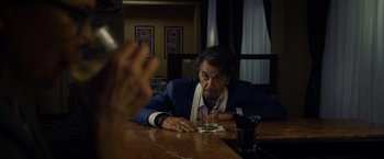 Movie still from “Danny Collins” (2015), directed by Dan Fogelman – An older man sitting at a table with a glass of wine; Medium shot, Over the shoulder angle
