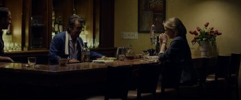 Movie still from “Danny Collins” (2015), directed by Dan Fogelman – Two people sitting at a table in front of drinks; Medium shot, Over the shoulder angle