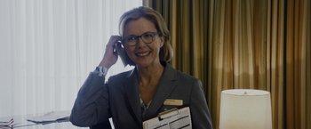 Movie still from “Danny Collins” (2015), directed by Dan Fogelman – A woman in a suit talking on a phone; Close Up shot, Over the shoulder angle